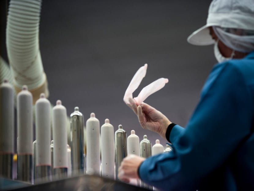 An employee of Japanese condom maker Sagami Rubber Industries performs quality tests for randomly picked condoms at the company's testing facility in Atsugi, Kanagawa prefecture.