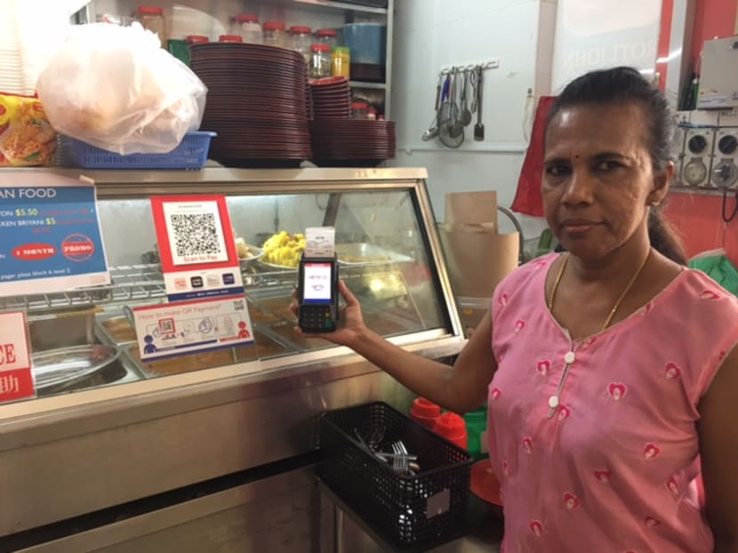 Food stall owner Florence Anthony with the QR code solution available for customers to pay for food. Photo: Tan Weizhen/TODAY