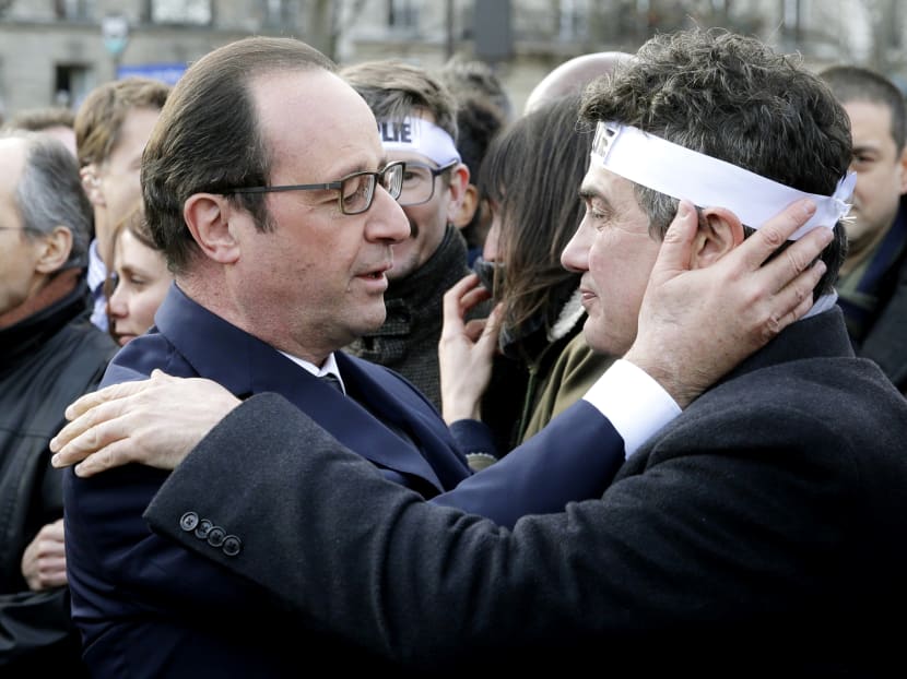 French President Francois Hollande (left) comforting Mr Patrick Pelloux, a columnist for Charlie Hebdo, during a solidarity march in Paris. Photo: AP