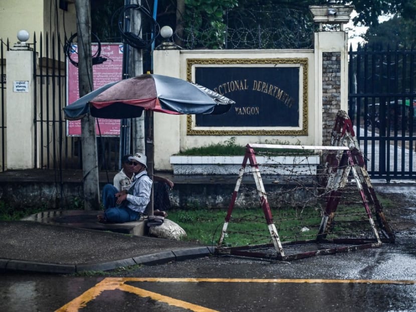 People sit in front of an entrance of Insein prison in Yangon on Oct 6, 2022. People sit in front of an entrance of Insein prison in Yangon on Oct 6, 2022.