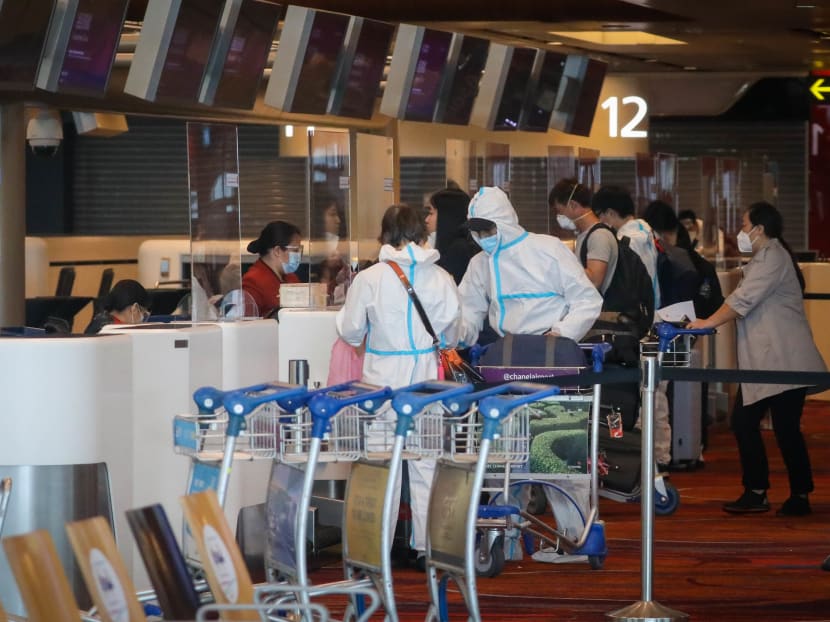 Departing passengers at Changi Airport Terminal 1 wearing personal protective equipment on May 14, 2021.