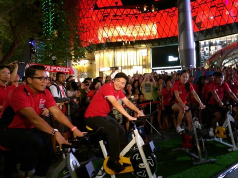 Minister for Culture, Community and Youth Lawrence Wong and Team Singapore athletes cycling to light up the SEA Games Arch. Photo: 28th SEA Games Twitter Page