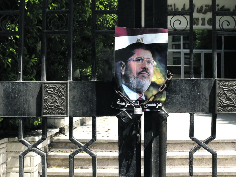 A picture of deposed President Mohamed Morsi outside the gates of a government building in Cairo, Egypt, yesterday. Photo: Reuters