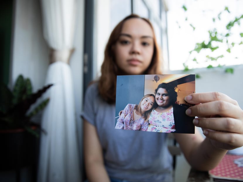 TODAY journalist Louisa Tang holding a photo of herself and her best friend. TODAY journalist Louisa Tang holding a photo of herself and her best friend.