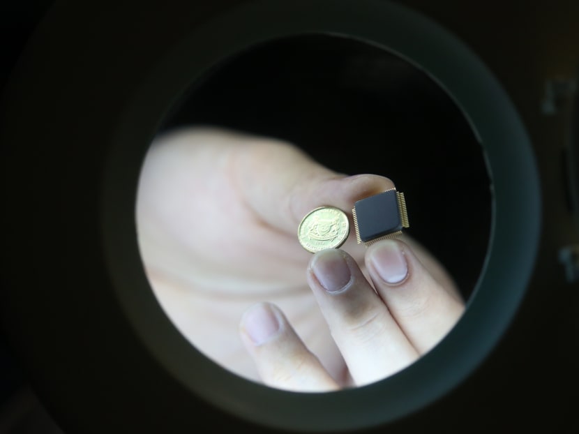 NTU scientists have developed a small smart chip, which analyses data patterns, that can be paired with brain implants which allows for the efficient wireless transmission of brain signals. Photo: Don Wong