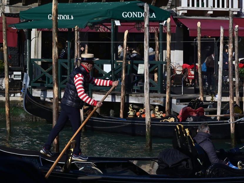 A gondolier rows a tourist in the Canal Grande in Venice on Dec 12, 2021.