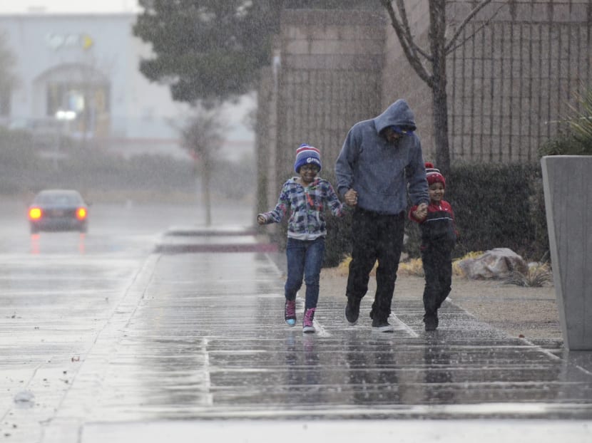 Mall of Victor Valley shoppers run for cover from the rain in Victorville, Calif., Tuesday, Jan. 5, 2016. Photo: AP