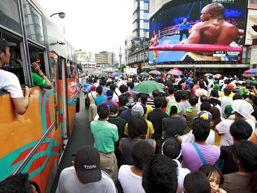 Fans watch the fight of Manny Pacquiao of the Philippines and Floyd Mayweather of U.S. on a live telecast monitor along a busy street in Manila May 3, 2015. Photo: Reuters