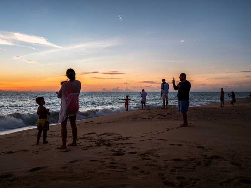 People enjoy the sunset at a beach in Phuket. Photo: Reuters