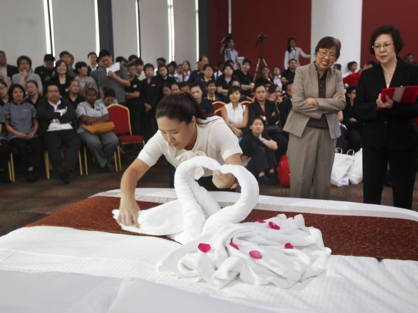 A hotel housekeeping staff member making a bed during the Hotel Housekeeping Challenge 2014. The SMP will also seek to improve job quality and identify emerging skills needs for the hotel industry. TODAY file photo