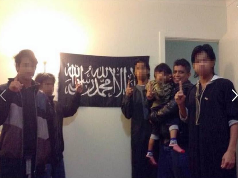A photo Zulfikar Shariff posted on his Facebook page of himself with his children in front of a flag used by jihadi terror groups. Photo: MHA