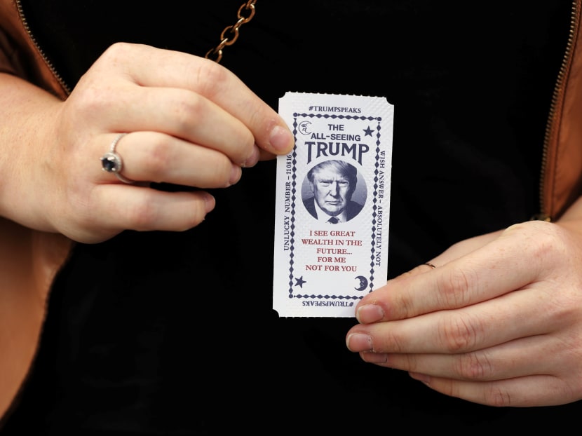 A woman holds a ticket dispensed from a Donald Trump themed fortune telling machine in Columbus Circle in New York, U.S., October 12, 2016. Photo: Reuters