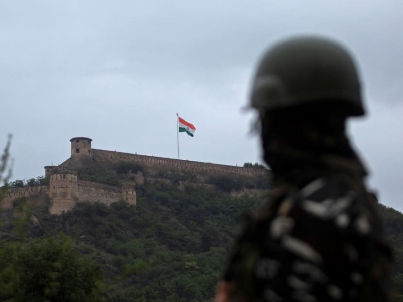 An Indian paramilitary soldier stands guard as Indian national flag flutters on Hari Parbat Fort during the celebrations to mark India's 75th Independence Day in Srinagar.
