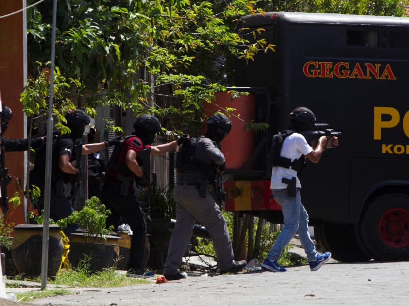Anti-terror policemen walk during a raid of a house of a suspected terrorist at Medokan Ayu area in Surabaya on Tuesday (May 15).