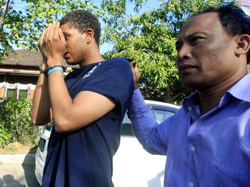 Indonesian police officer escort Commy Schaefer (left) taking in for question at a police station during in Bali, Indonesia, Aug 13, 2014. Photo: AP