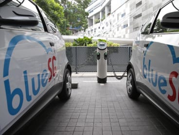 BlueSG electric vehicles parked at a charging station in a car park. 