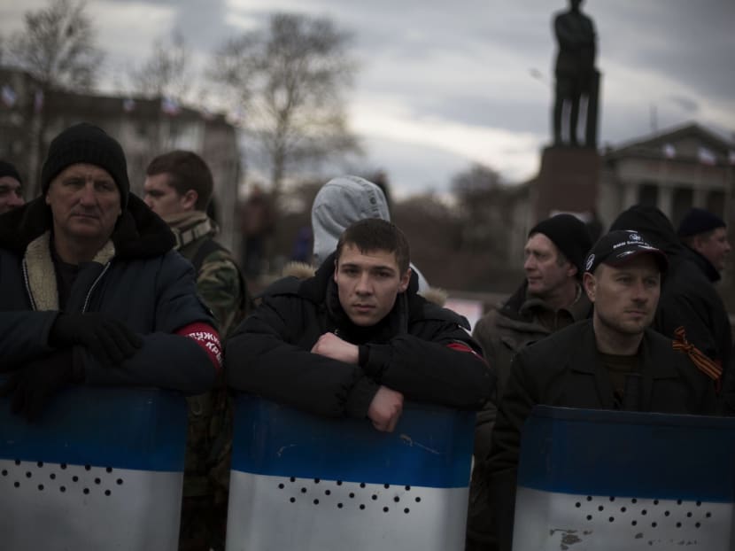 Volunteers of a self defence group stand guard in Lenin Square after marching in the center of Simferopol, Crimea, Ukraine, on March 8, 2014. Photo: AP