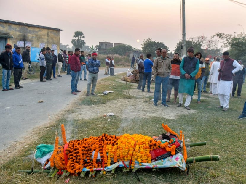Villagers gather near a body of a victim before the last rites, who lost his life after consuming locally made tipple known as "Mahua" or "Desi Daru" in Bahrauli about 35 kms from Chapra in India’s Bihar state on December 17, 2022.