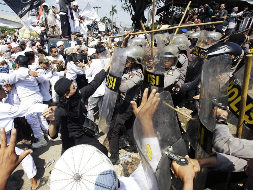 Police officers clash with Muslim hardliners during a protest against the construction of a Catholic church in Bekasi, Indonesia, yesterday. The church has been targeted since it obtained its permit in June 2015. Photo: AP
