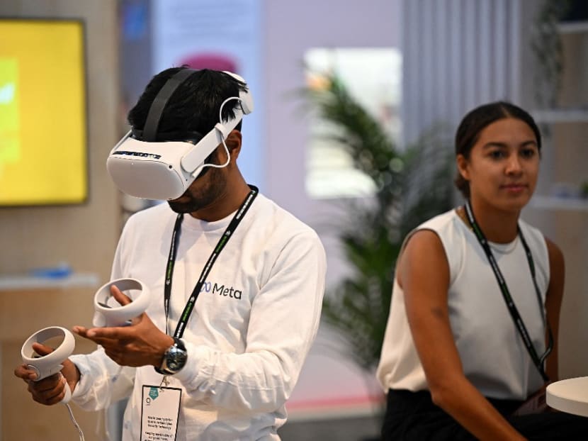 A Meta worker uses a virtual reality headset on a stand on the second day of the annual Conservative Party Conference in Birmingham, central England, on Oct 3, 2022.