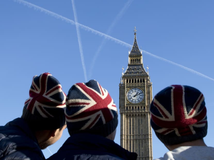 File photo of people wearing Union flag-themed hats as they look at the Elizabeth Tower, better known as "Big Ben", near the Houses of Parliament in London on Jan 17, 2017. Photo: AFP
