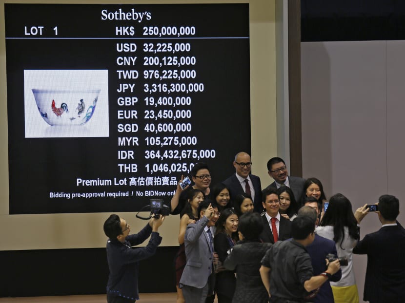 Staff members of Sotheby’s take a group pictures after the auction of a Meiyintang "Chicken Cup” from the Chinese Ming Dynasty (1368-1644)  in Hong Kong, on April 8, 2014. Photo: AP