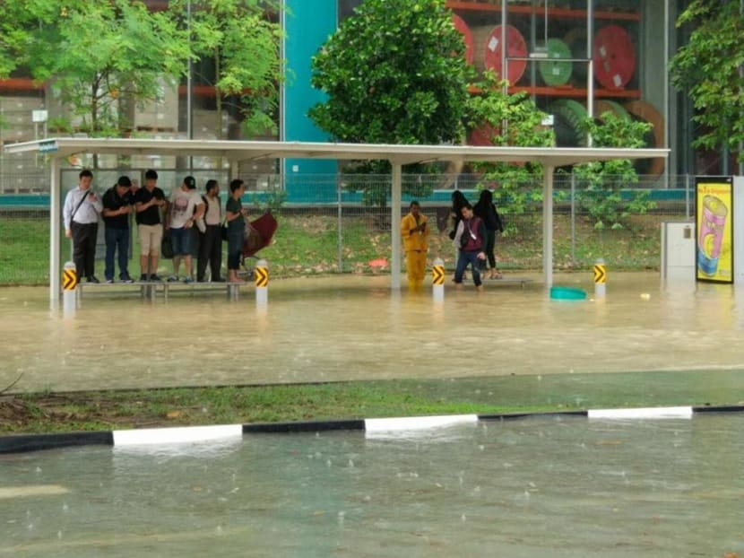 Commuters waiting for their respective buses are seen standing on benches to avoid the flood waters on Jan 8, 2018. Photo: Social media