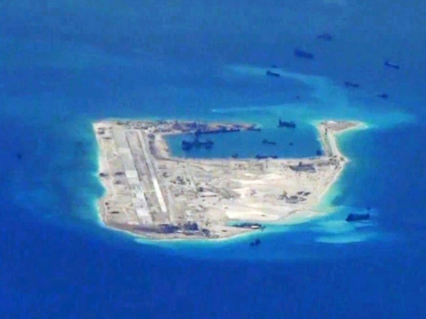 Chinese dredging vessels purportedly seen around Fiery Cross Reef in the disputed South China Sea. China has ignored a Hague ruling against its claims, and presses on with reclamation and construction in the area. Photo: REUTERS/U.S. Navy