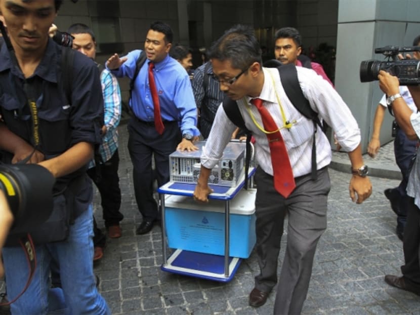 Officers from the special task force remove what looked like a CPU and a box from the 1MDB office at Menara IMC in Kuala Lumpur, July 8, 2015. Photo: The Malay Mail Online