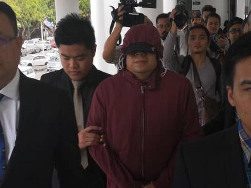 Former deputy director with Sabah Water Teo Chee Kong (in maroon hoodie) being led to court. He claimed trial on Wednesday (Dec 13) to 146 counts of misappropriation of funds totalling S$10.6 million. Photo: Malay Mail Online
