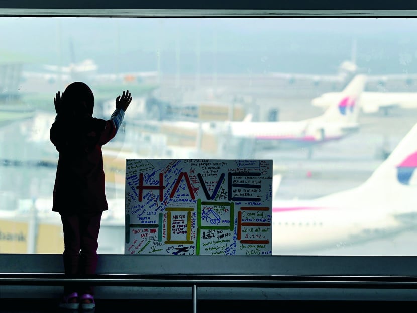 A girl stands next to a cardboard reading “Have Hope” written by the public at Kuala Lumpur International Airport in Sepang, Malaysia, Monday, March 10, 2014. Photo: AP