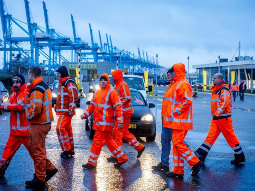 Container port workers walk past a picket line at the port in Rotterdam on Jan 7, 2016 during a strike calling for job guarantees until 2020. Photo: AFP
