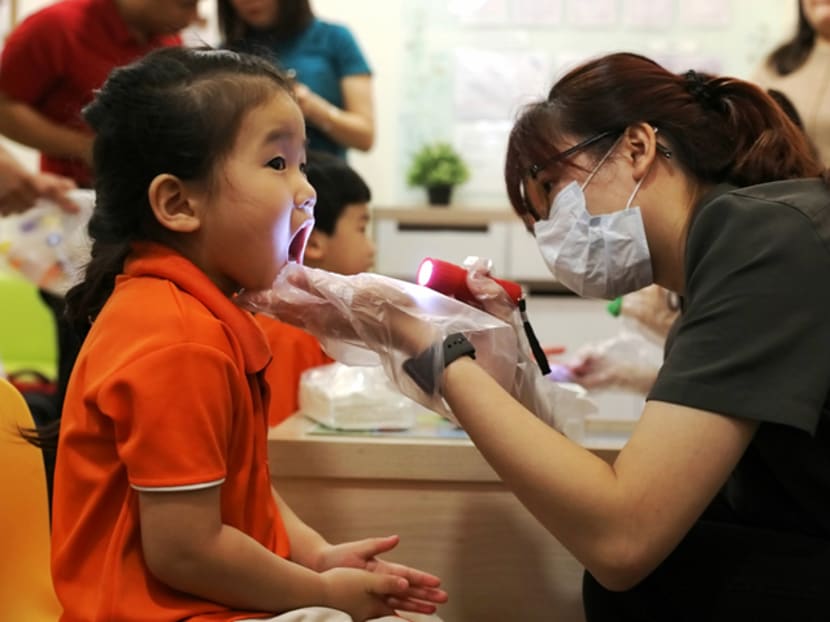 Preschool children being checked by teachers at My First Skool in Buangkok Crescent on Jan 28, 2020.