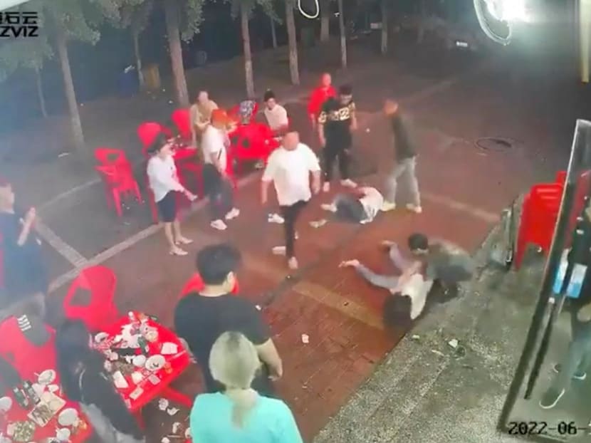 Two women lie on the ground after being assaulted by a group of men outside a restaurant in the northeastern city of&nbsp;Tangshan on June 10, 2022.