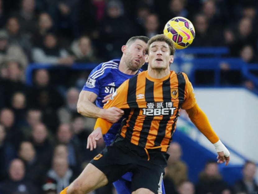 Cahill, challenging Hull City’s Nikica Jelavic (front) on Saturday, was defended by Chelsea manager Jose Mourinho for his ‘simulation’ in the penalty area. Photo: Reuters