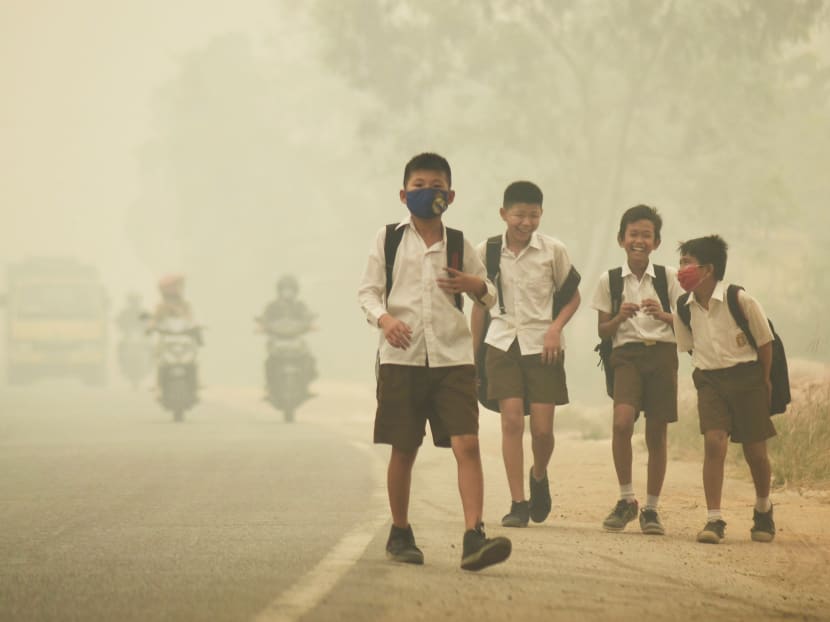Students walk along a street as they are released from school to return home earlier due to the haze in Jambi, Indonesia's Jambi province, September 29, 2015 in this picture taken by Antara Foto. Photo: Reuters