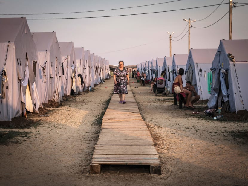 A woman walking among tents at a refugee camp in Donetsk, Russia, on the border with Ukraine. Photo: The New York Times