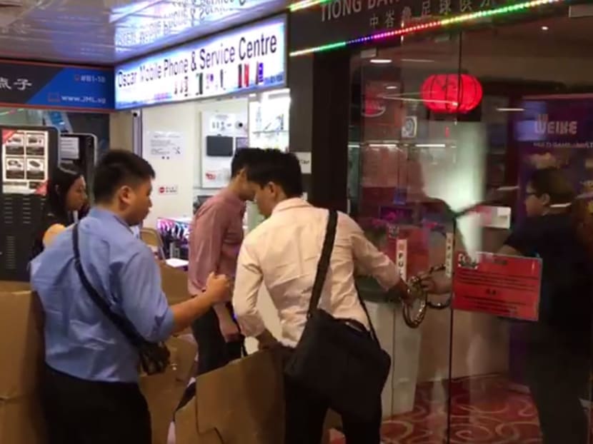 A still from a video showing investigators carrying cardboard boxes into the Tiong Bahru FC clubhouse.