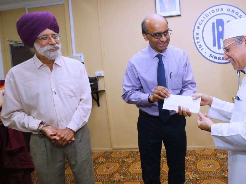 President of IRO Mr Gurmit Singh (left) looks on as Iman Habib Hassan (right) hands over to Deputy Prime Minister Tharman  Shanmugaratnam a cheque donation on behalf of the IRO, for the quake victims in Nepal. Photo. Ernest Chua