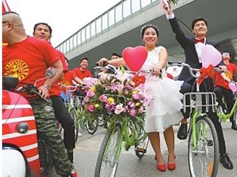 The couple pictured on their wedding day bikes. Photo: QQ.com