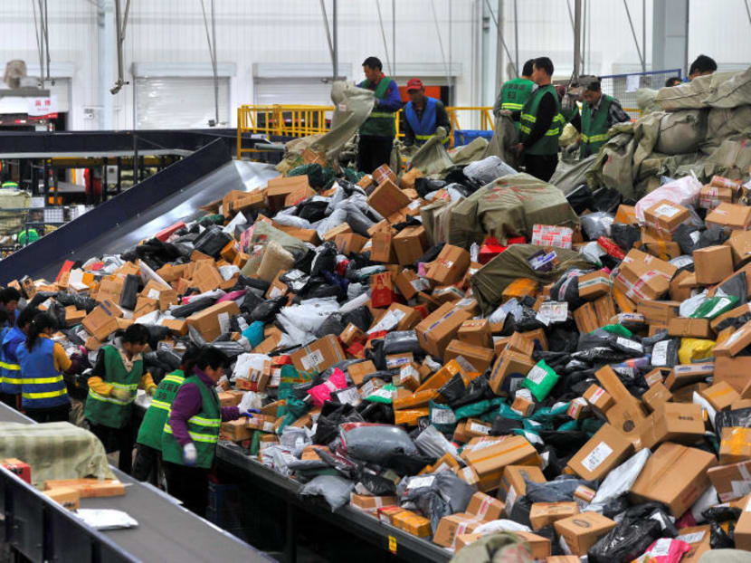 Employees sort boxes and parcels at a logistic centre in in Jinan, Shandong province, China,  after the Singles' Day online shopping festival. An estimated 30,000 orders placed with Ezbuy were disrupted due to its ongoing problems with a China e-commerce site. Photo: Reuters