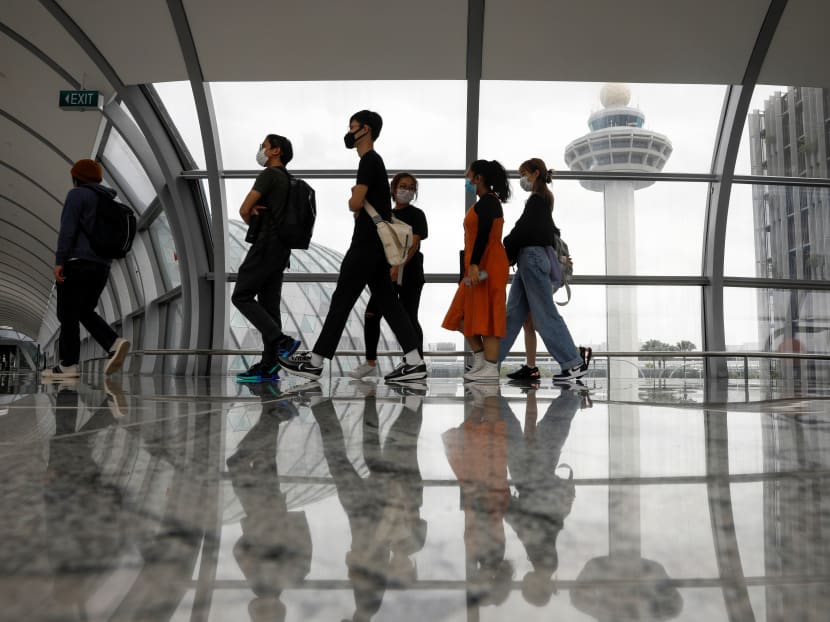 People passing the control tower of Changi Airport.