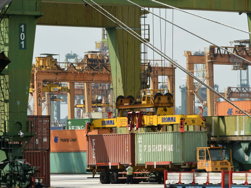A worker monitors as containers are lifted onto a trailer at Keppel port terminal in Singapore on Jan 18, 2016. Photo: AFP