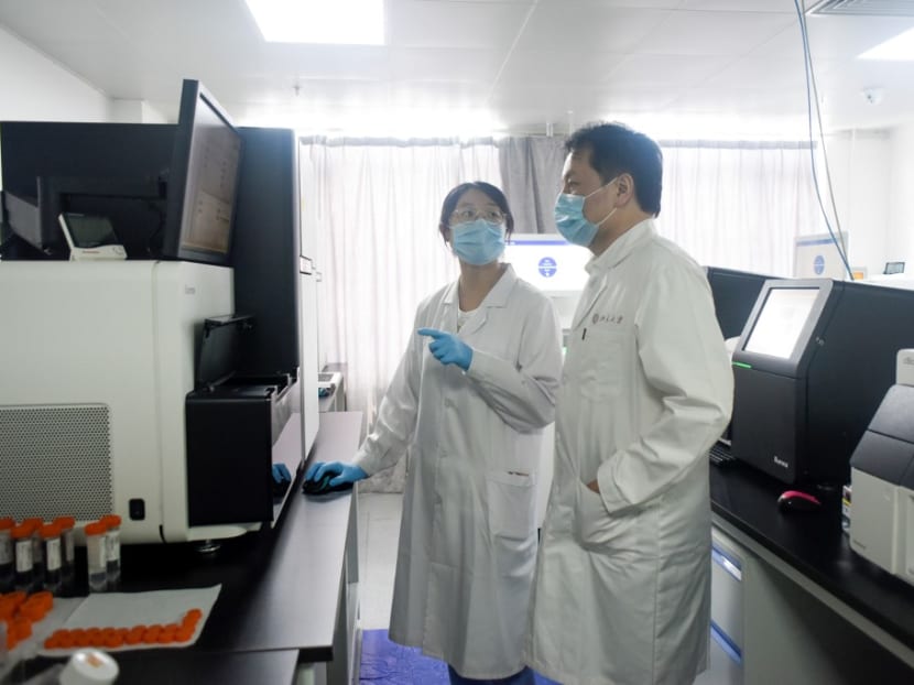 Director of Peking University's Beijing Advanced Innovation Center for Genomics Sunney Xie with a member of his research team at their laboratory in Beijing.