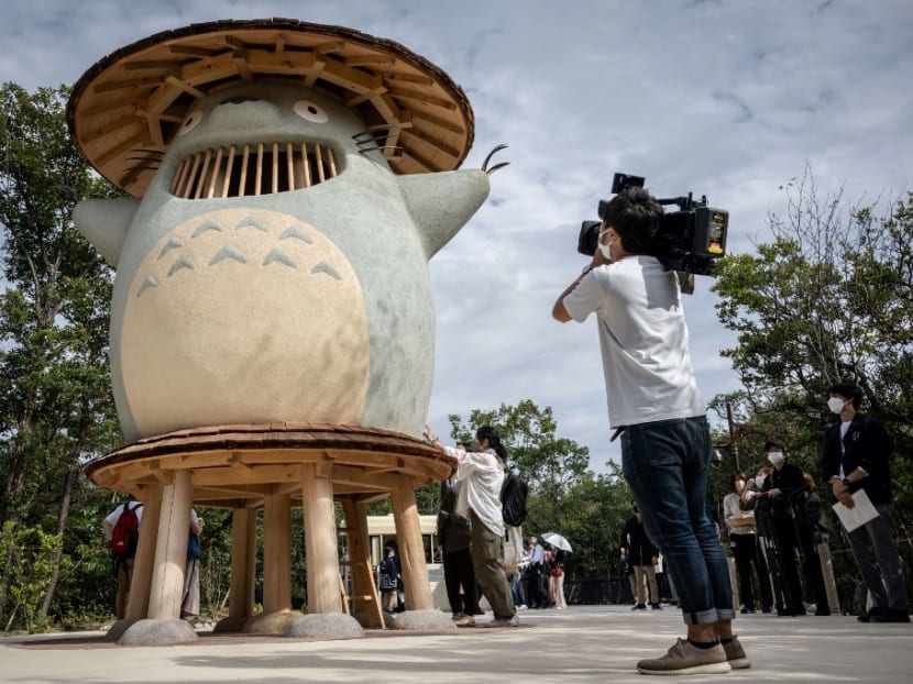 A member of the media takes video of an exhibit of Ghibli character 'Totoro' at Dondoko Forest during a media tour of the new Ghibli Park in Nagakute, Aichi prefecture on Oct 12, 2022. 