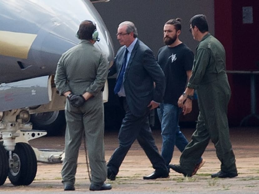 The "hipster cop" escorting once powerful lawmaker Eduardo Cunha has been identified as Lucas Valenca, background in T-shirt. Photo: AFP