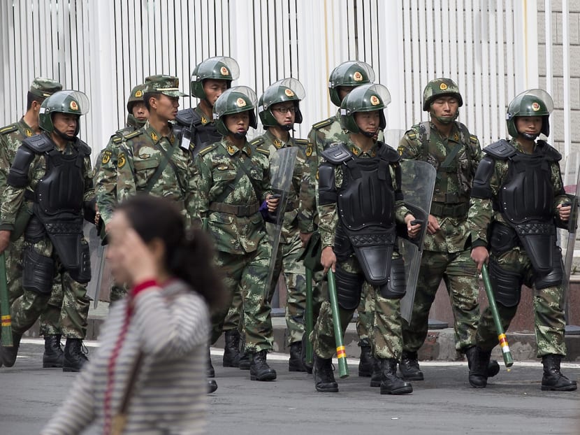 In this file photo, paramilitary policemen with shields and batons patrolling near the People's Square in Urumqi, China's northwestern region of Xinjiang. Photo: AP
