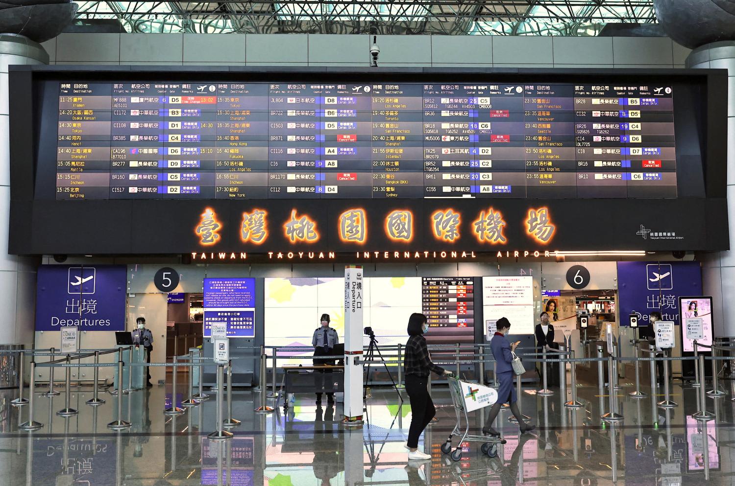 People walk past the departure gate at Taoyuan International Airport in Taoyuan, Taiwan, Aug 4, 2022. 