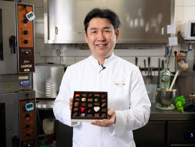 Japanese chocolatier Yasushi Sasaki holds a box of chocolates as he poses for a photograph in his workshop in the Brussels commune of Woluwe-Saint-Pierre on March 14, 2024.