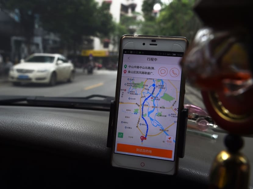 A taxi driver uses the Didi Chuxing app while driving along a street in Guilin, in China's southern Guangxi region on May 13, 2016. Photo: AFP